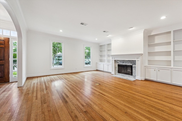 1976 Vermont St, Houston, TX 77019 - unfurnished living room with plenty of natural light, a fireplace, light wood-style flooring, built in shelves, and ornamental molding