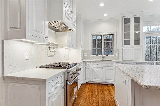 1976 Vermont St, Houston, TX 77019 - kitchen featuring high end stainless steel range, light wood finished floors, backsplash, recessed lighting, and glass insert cabinets