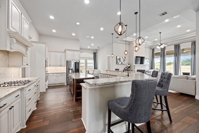19219 Spotted Bass Ln, Cypress, TX 77433 - kitchen with stainless steel appliances, a large island with sink, a breakfast bar area, open floor plan, and decorative backsplash