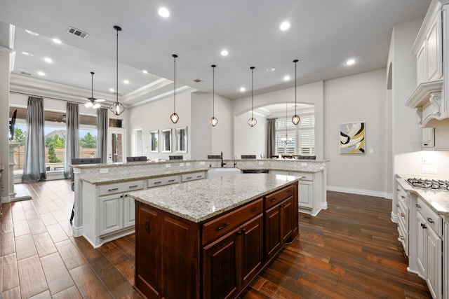 19219 Spotted Bass Ln, Cypress, TX 77433 - kitchen with a large island with sink, dark wood-style floors, white cabinets, and recessed lighting