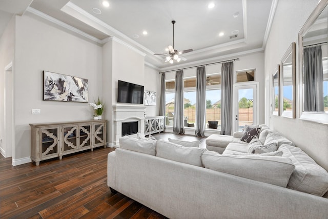 19219 Spotted Bass Ln, Cypress, TX 77433 - living area featuring crown molding, dark wood-type flooring, a raised ceiling, a ceiling fan, and a fireplace