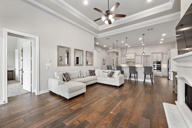 19219 Spotted Bass Ln, Cypress, TX 77433 - living area with a tray ceiling, ceiling fan, crown molding, dark wood finished floors, and recessed lighting