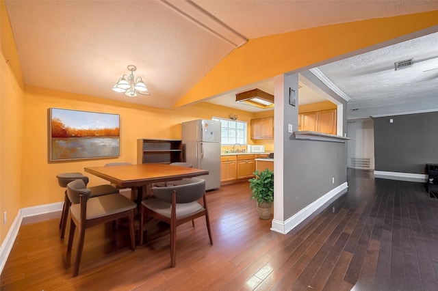 4610 Brinkman St, Houston, TX 77018 - dining area featuring a chandelier, a textured ceiling, vaulted ceiling, and dark wood-type flooring