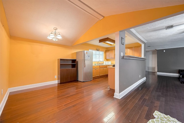 4610 Brinkman St, Houston, TX 77018 - kitchen featuring freestanding refrigerator, a chandelier, dark wood-type flooring, lofted ceiling, and white microwave