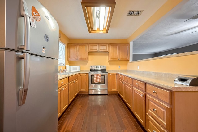 4610 Brinkman St, Houston, TX 77018 - kitchen with white appliances, light countertops, dark wood-style flooring, light brown cabinetry, and a peninsula