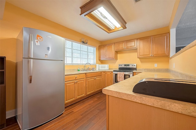 4610 Brinkman St, Houston, TX 77018 - kitchen featuring freestanding refrigerator, stainless steel electric range, light countertops, light brown cabinetry, and wood finished floors