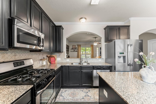 4663 Trembling Forest Ln, Houston, TX 77092 - kitchen featuring stainless steel appliances, arched walkways, light stone counters, and crown molding