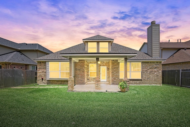 6230 Ledger Ln, Missouri City, TX 77459 - back of property featuring brick siding, roof with shingles, a fenced backyard, and a patio area