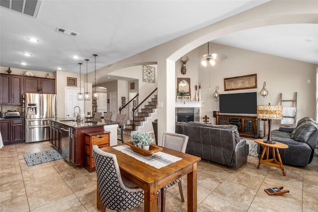 19334 St Winfred Dr, Spring, TX 77379 - dining room featuring a fireplace, arched walkways, recessed lighting, light tile patterned floors, and stairs
