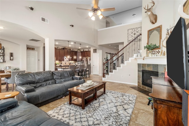 19334 St Winfred Dr, Spring, TX 77379 - living room featuring arched walkways, a ceiling fan, high vaulted ceiling, stairs, and light tile patterned flooring