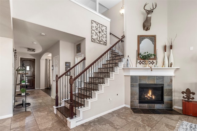 19334 St Winfred Dr, Spring, TX 77379 - entrance foyer featuring stairway, arched walkways, a towering ceiling, and a tiled fireplace