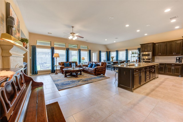 3411 Brampton Island Dr, Katy, TX 77494 - kitchen with open floor plan, a kitchen breakfast bar, dark brown cabinetry, a ceiling fan, and recessed lighting