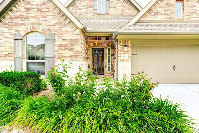 3411 Brampton Island Dr, Katy, TX 77494 - doorway to property with a shingled roof, an attached garage, brick siding, and concrete driveway