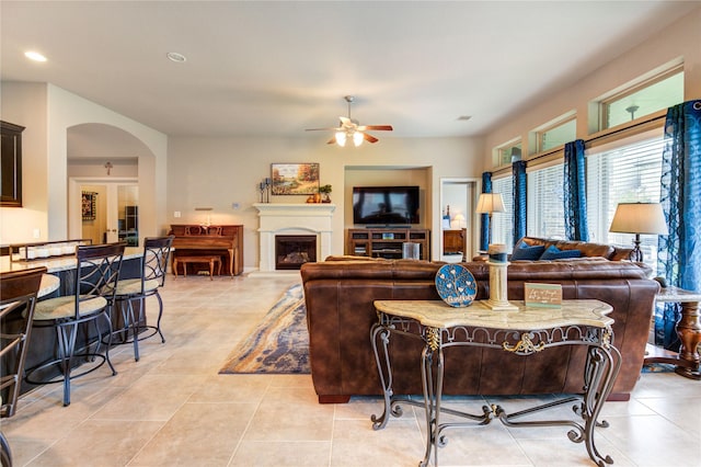 3411 Brampton Island Dr, Katy, TX 77494 - living room featuring a ceiling fan, light tile patterned flooring, recessed lighting, arched walkways, and a fireplace with raised hearth