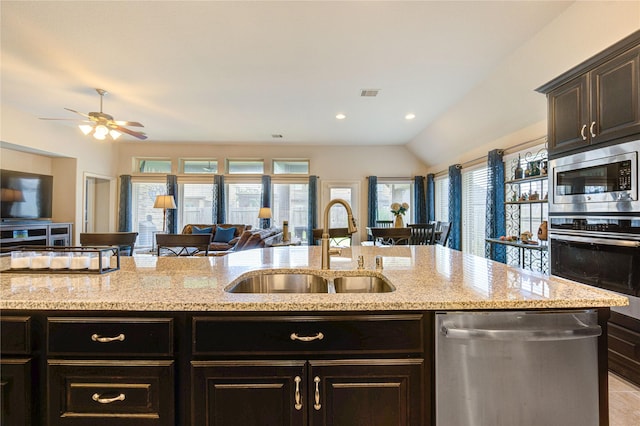3411 Brampton Island Dr, Katy, TX 77494 - kitchen with appliances with stainless steel finishes, open floor plan, healthy amount of natural light, light stone countertops, and lofted ceiling