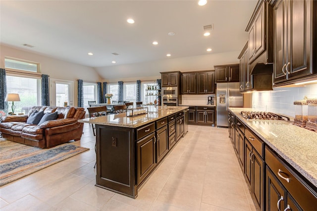 3411 Brampton Island Dr, Katy, TX 77494 - kitchen with stainless steel appliances, a kitchen breakfast bar, open floor plan, backsplash, and healthy amount of natural light