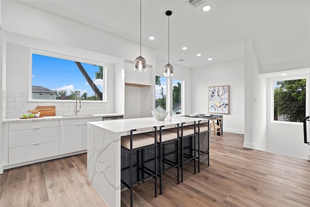 216 E 31st 1/2 St Unit B, Houston, TX 77018 - kitchen featuring modern cabinets, white cabinets, light wood-style floors, tasteful backsplash, and recessed lighting