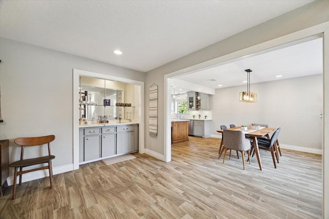 1802 Cedar Creek Ct, Houston, TX 77077 - dining room featuring light wood-type flooring, bar with sink, recessed lighting, and a chandelier
