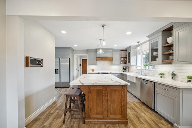 1802 Cedar Creek Ct, Houston, TX 77077 - kitchen featuring stainless steel appliances, open shelves, gray cabinetry, a kitchen island, and decorative backsplash