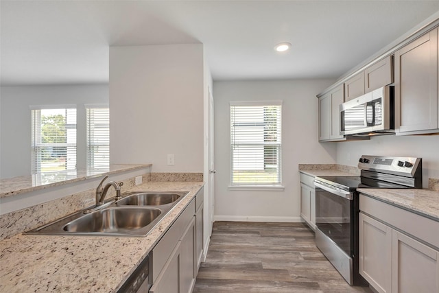 1316 Farquhar St, Navasota, TX 77868 - kitchen with appliances with stainless steel finishes, wood finished floors, recessed lighting, and gray cabinetry