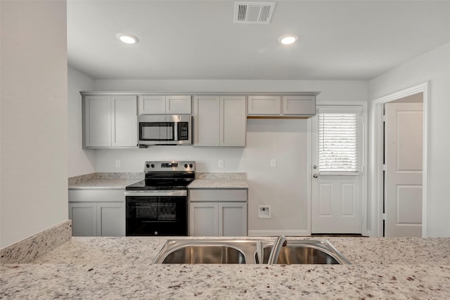 1316 Farquhar St, Navasota, TX 77868 - kitchen with appliances with stainless steel finishes, gray cabinetry, and recessed lighting