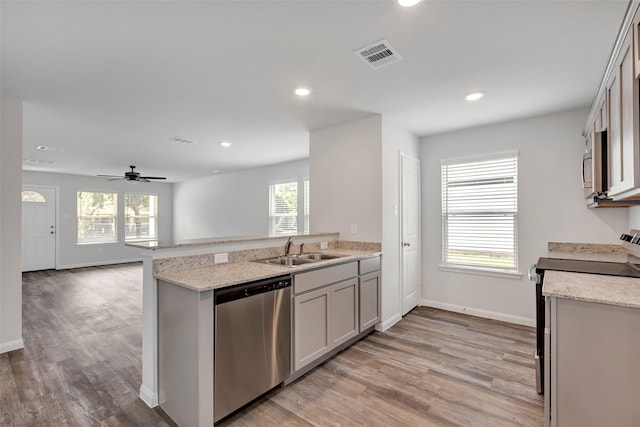 1316 Farquhar St, Navasota, TX 77868 - kitchen with stainless steel appliances, light wood finished floors, a peninsula, recessed lighting, and a ceiling fan