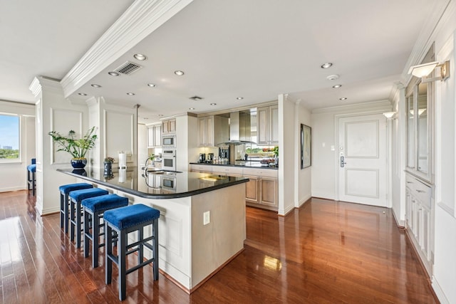 49 Briar Hollow Ln Unit 702, Houston, TX 77027 - kitchen with wall chimney exhaust hood, dark countertops, crown molding, recessed lighting, and dark wood-style flooring