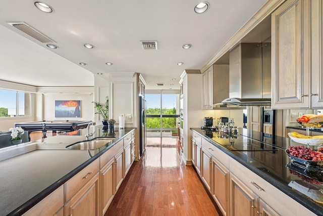 49 Briar Hollow Ln Unit 702, Houston, TX 77027 - kitchen with black electric stovetop, recessed lighting, fridge, wood finished floors, and dark stone countertops