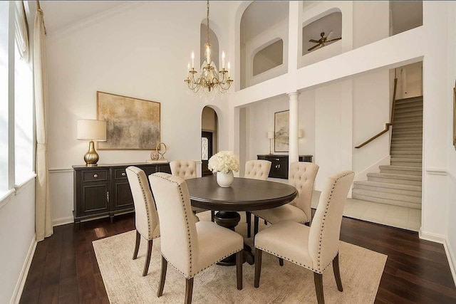 6423 Middlelake Ct, Katy, TX 77450 - dining space featuring arched walkways, dark wood-type flooring, a chandelier, stairway, and a towering ceiling