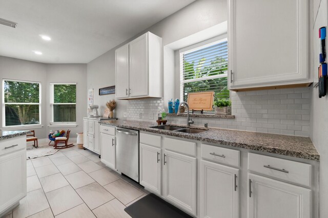 23803 Spring Way Dr, Spring, TX 77373 - kitchen featuring stainless steel dishwasher, backsplash, white cabinets, stone countertops, and light tile patterned floors