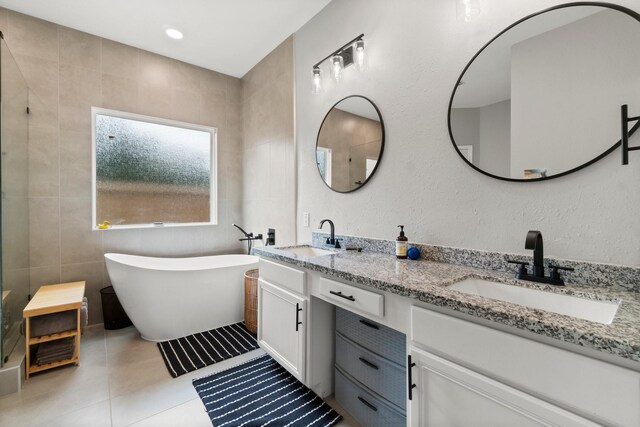 23803 Spring Way Dr, Spring, TX 77373 - full bathroom with double vanity, a freestanding tub, tile patterned flooring, and tile walls