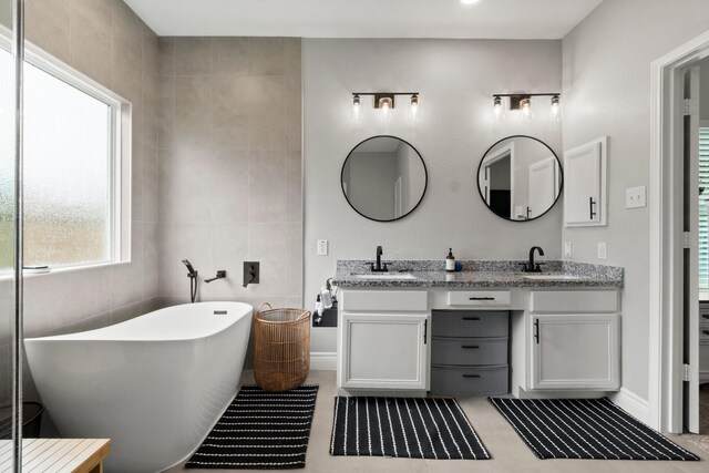 23803 Spring Way Dr, Spring, TX 77373 - full bath with double vanity, a freestanding bath, and tile walls