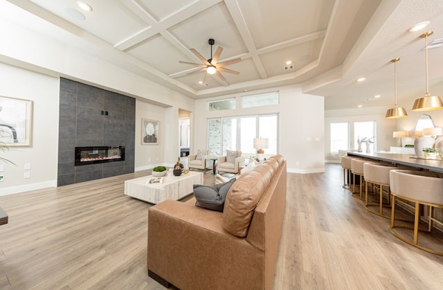 19207 Seabiscuit Stable Trl, Tomball, TX 77377 - living room featuring ceiling fan, a tiled fireplace, coffered ceiling, light wood finished floors, and recessed lighting