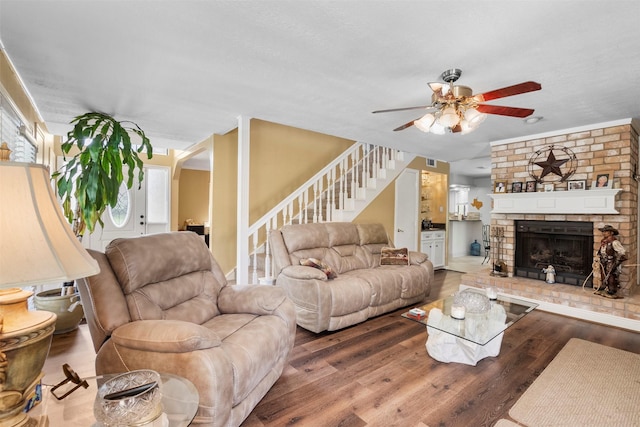 19511 Oak Station Dr, Humble, TX 77346 - living room with ceiling fan, stairway, wood finished floors, and a fireplace