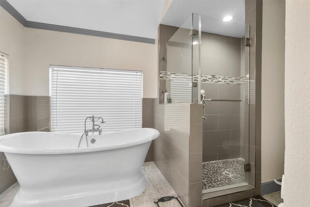 19511 Oak Station Dr, Humble, TX 77346 - bathroom featuring a shower stall, a soaking tub, tile walls, and crown molding