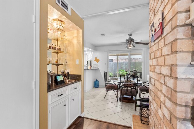 19511 Oak Station Dr, Humble, TX 77346 - indoor bar with ceiling fan, light tile patterned floors, and brick wall