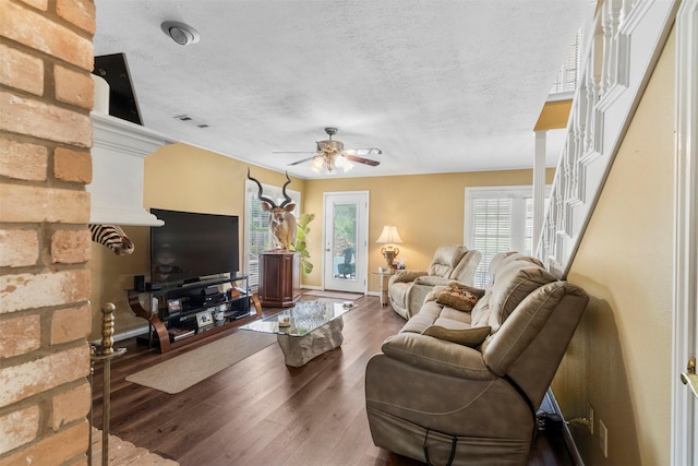 19511 Oak Station Dr, Humble, TX 77346 - living area with ceiling fan, wood finished floors, a textured ceiling, and stairs