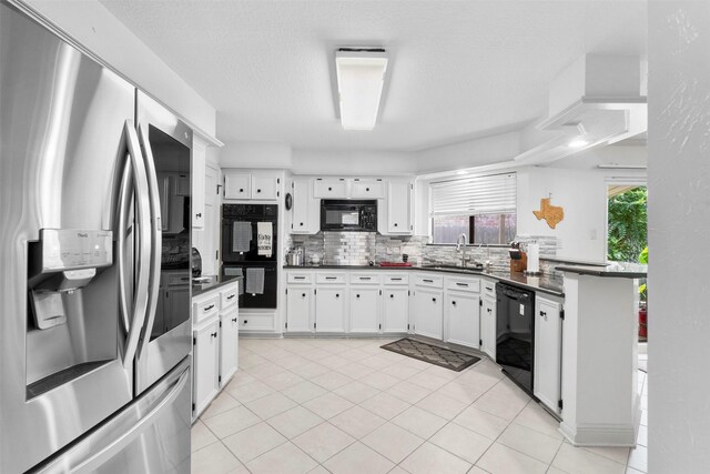 19511 Oak Station Dr, Humble, TX 77346 - kitchen featuring black appliances, dark countertops, and white cabinetry