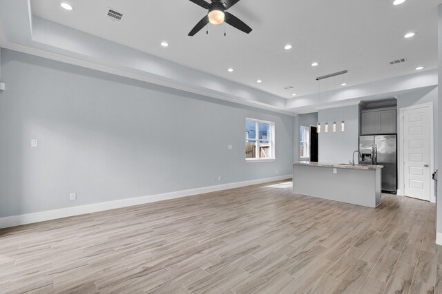 2811 Wichita St, Houston, TX 77004 - unfurnished living room featuring a tray ceiling, a ceiling fan, light wood-type flooring, and recessed lighting