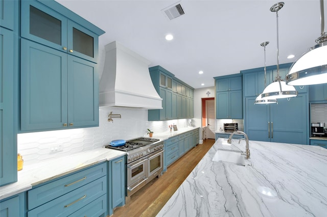1353 Chantilly Ln, Houston, TX 77018 - kitchen with custom exhaust hood, backsplash, light wood-type flooring, glass insert cabinets, and recessed lighting