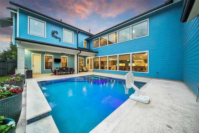 1353 Chantilly Ln, Houston, TX 77018 - back of house at dusk featuring a patio, an in-ground hot tub, and outdoor dining space