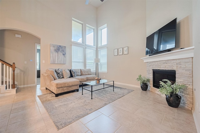 2526 Granberry Pt, Missouri City, TX 77459 - tiled living area featuring a towering ceiling, ceiling fan, plenty of natural light, stairway, and arched walkways