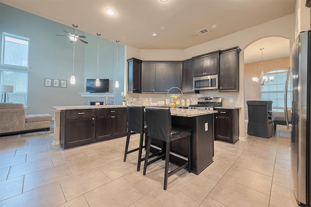 2526 Granberry Pt, Missouri City, TX 77459 - kitchen featuring stainless steel appliances, a chandelier, a ceiling fan, open floor plan, and tasteful backsplash