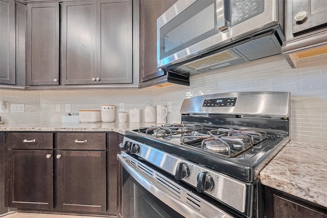 2526 Granberry Pt, Missouri City, TX 77459 - kitchen with appliances with stainless steel finishes, decorative backsplash, dark brown cabinets, and light stone counters