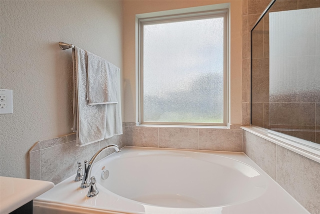 2526 Granberry Pt, Missouri City, TX 77459 - full bathroom with a garden tub, plenty of natural light, and a textured wall