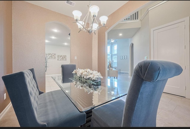 2526 Granberry Pt, Missouri City, TX 77459 - dining space with arched walkways, a chandelier, a textured wall, light tile patterned floors, and a ceiling fan