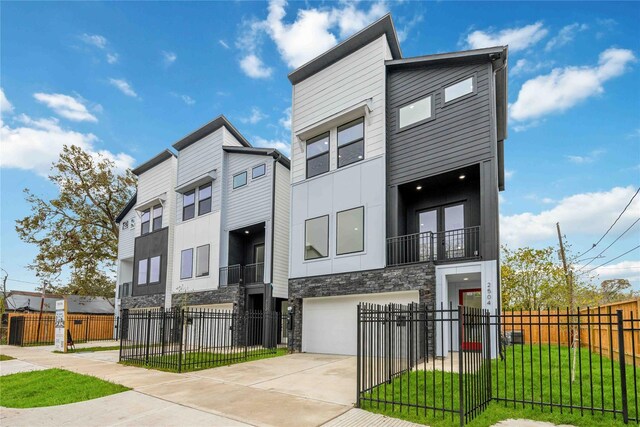 2506 Tierwester St, Houston, TX 77004 - view of front facade with stone siding, concrete driveway, an attached garage, a fenced front yard, and a balcony