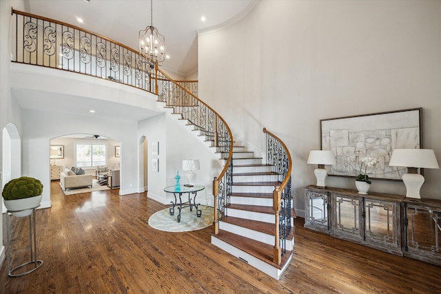 3310 Glen Haven Blvd, Houston, TX 77025 - stairs featuring arched walkways, wood finished floors, a towering ceiling, ornamental molding, and a chandelier