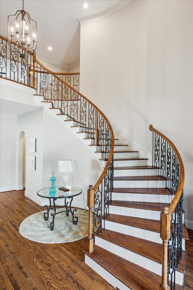 3310 Glen Haven Blvd, Houston, TX 77025 - staircase with arched walkways, wood finished floors, a high ceiling, a chandelier, and recessed lighting