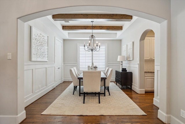 3310 Glen Haven Blvd, Houston, TX 77025 - dining area featuring a chandelier, arched walkways, beam ceiling, a decorative wall, and dark wood-style flooring